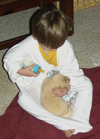 photo of Alex feeding a puppy
