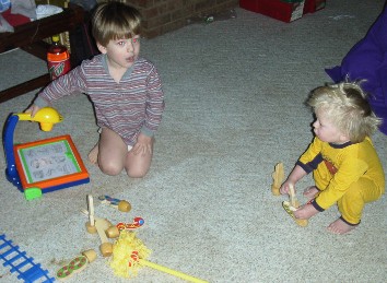 photo of Alex playing with his drawing board and Ben playing with the number bowling pins