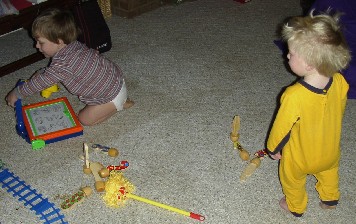 photo of Alex playing with his drawing board and Ben playing with the number bowling pins