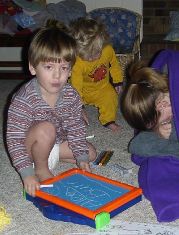 photo of Alex playing with his chalk board and Ben in the background
